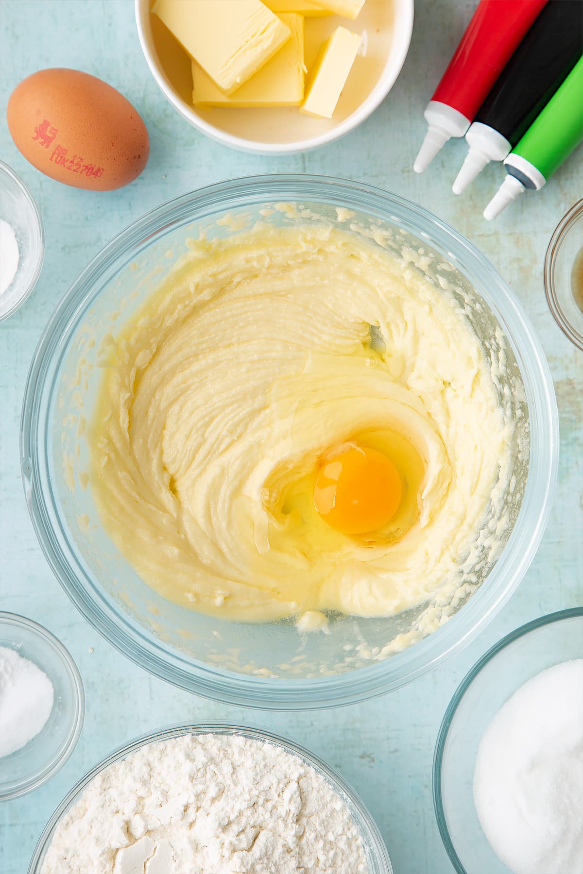 Overhead shot of an egg on fluffy butter mix in a bowl