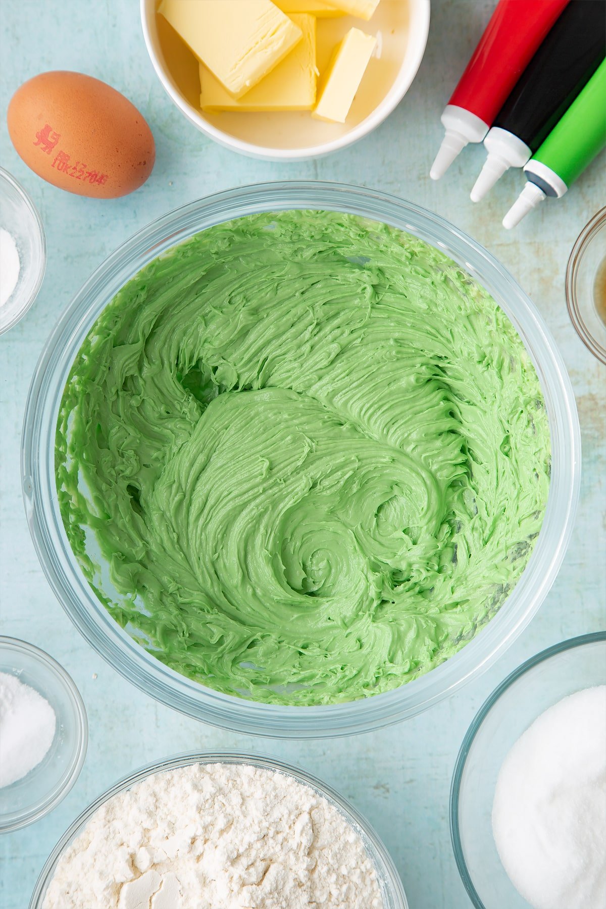 Overhead shot of green butter mix in a clear bowl