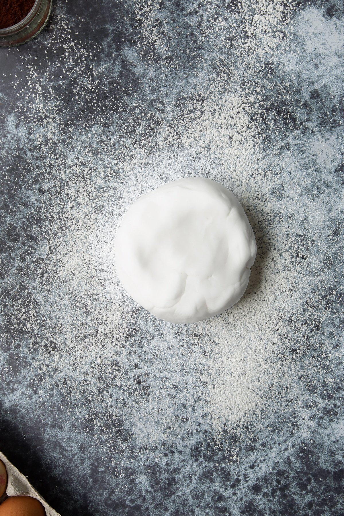 Ball of white sugar paste on a cornflour dusted surface.