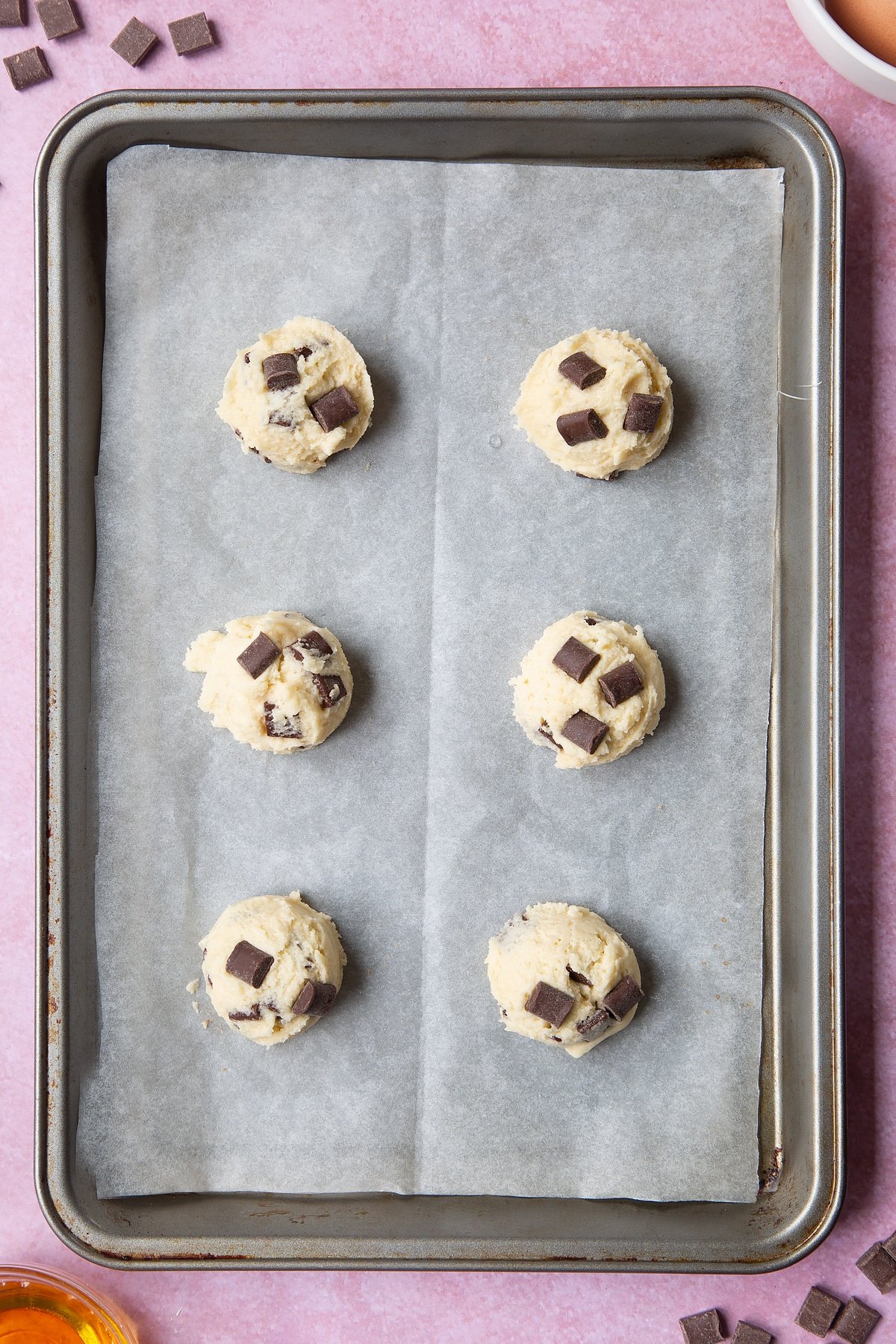 Overhead shot of chewy dark chocolate chip cookies dough on a baking tray