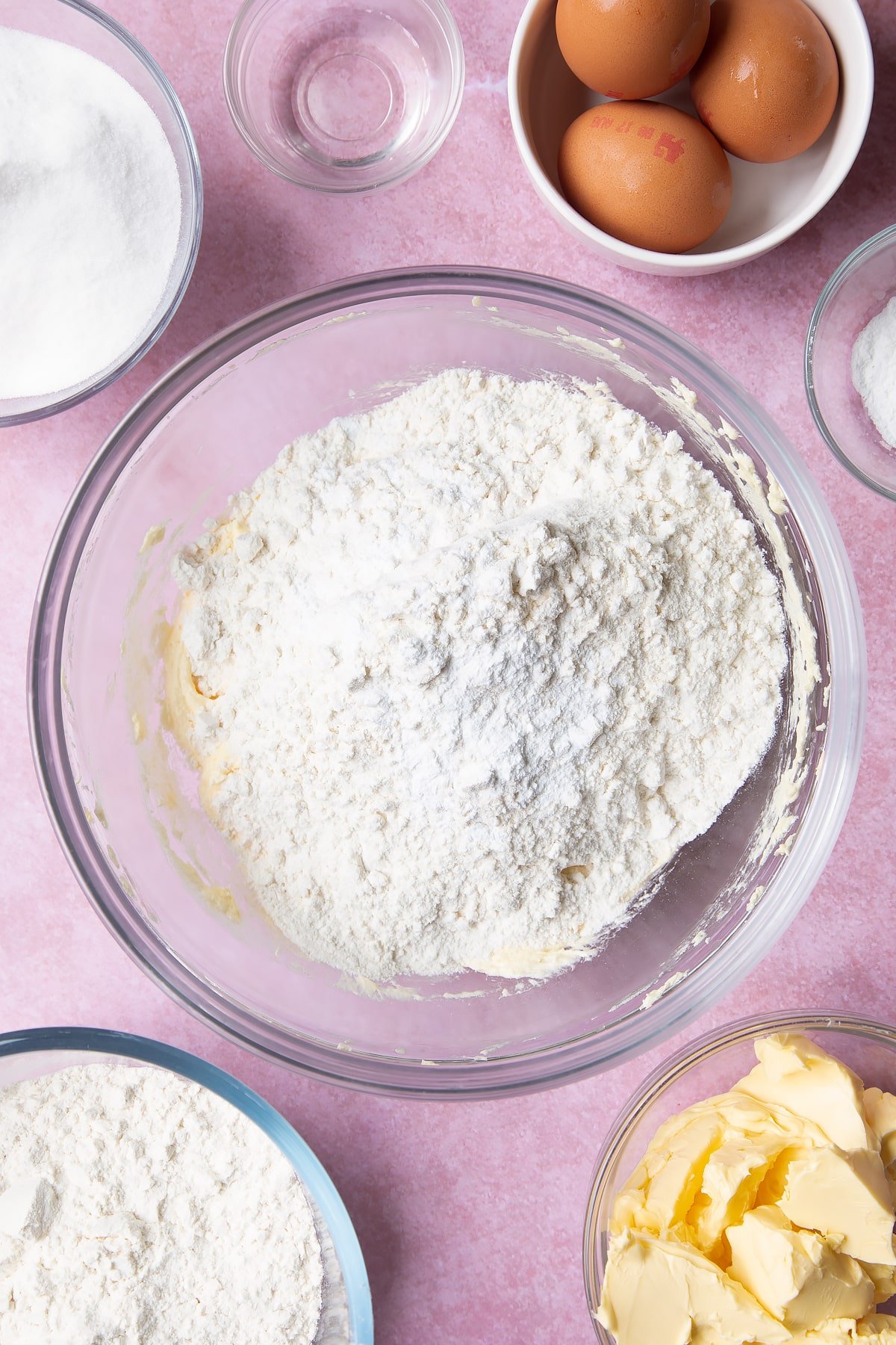 Adding more flour to the mixing bowl.