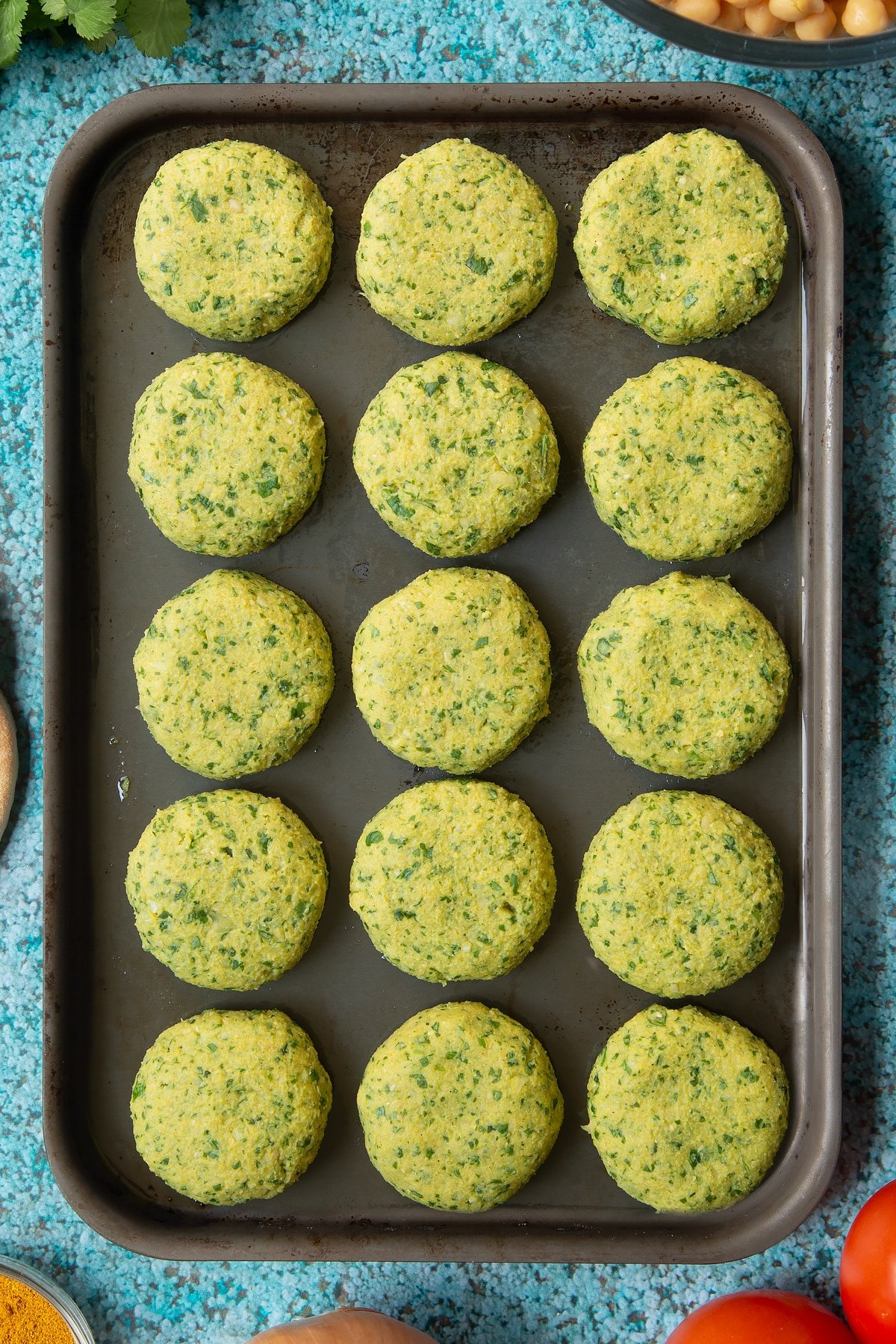 Raw gluten-free falafel on a baking tray.