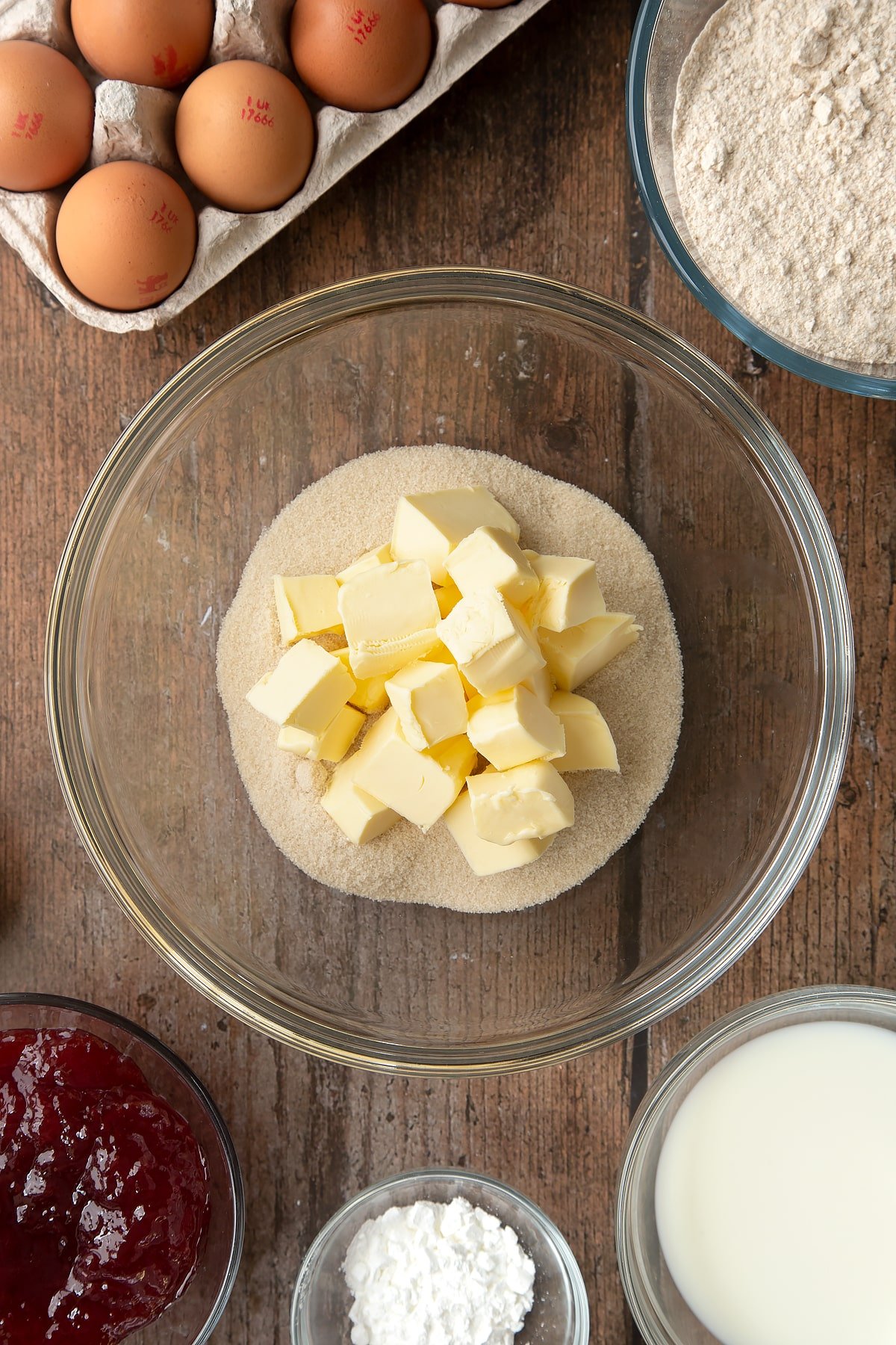 Overhead shot of sugar and butter in a large clear mixing bowl