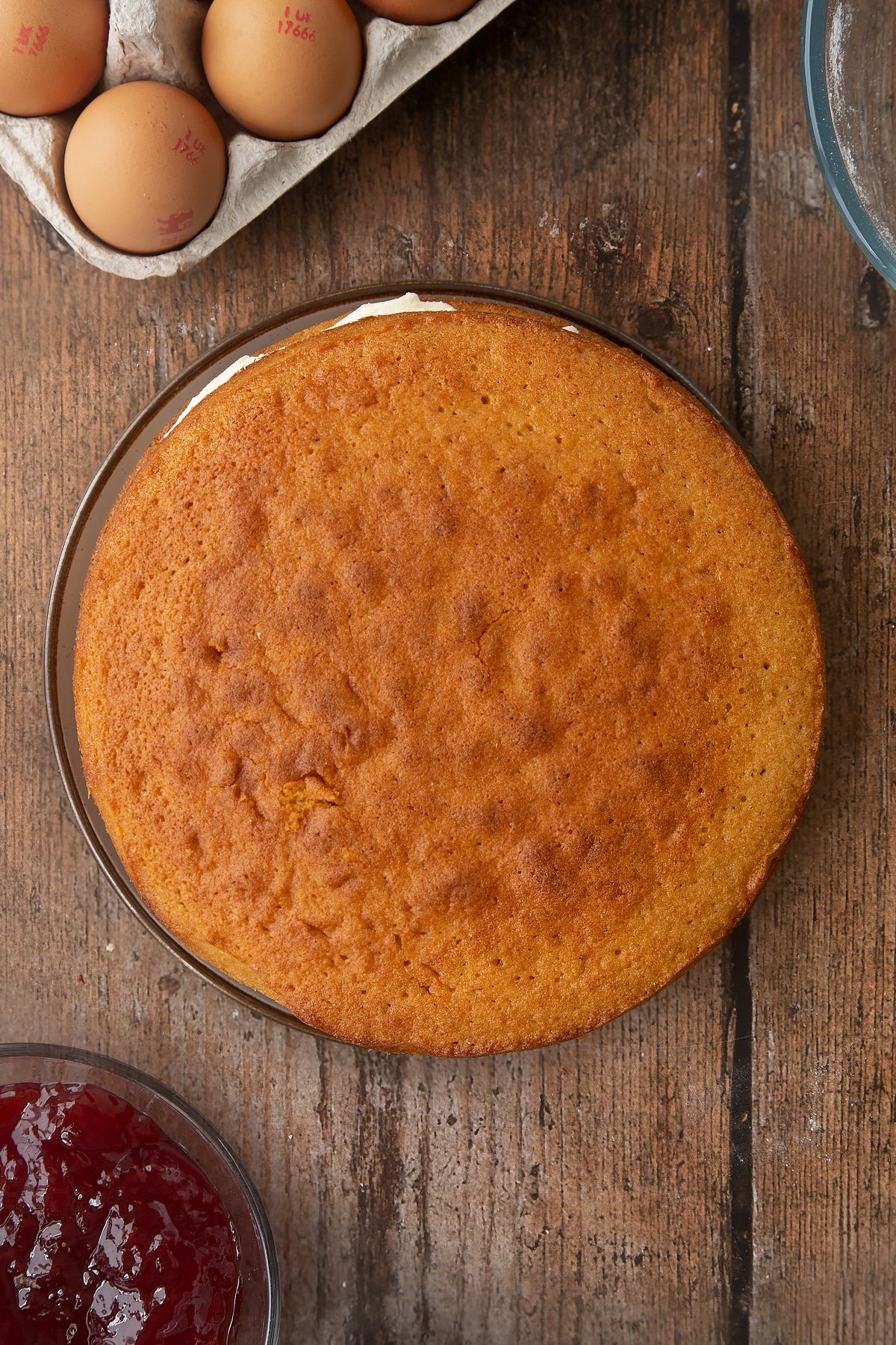 Overhead shot of the top of the golden syrup sponge cake being applied. 