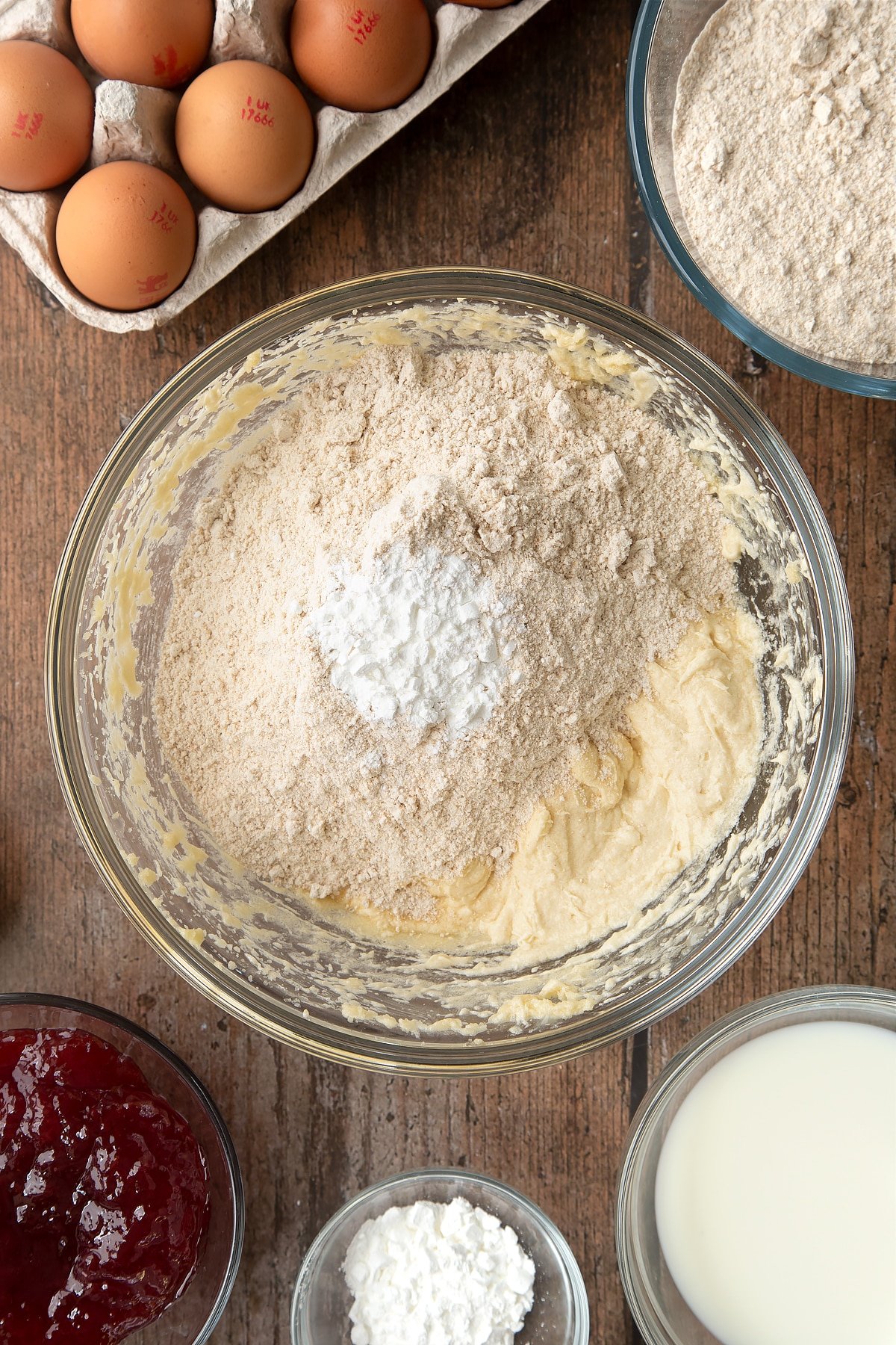 Overhead shot of flour and baking powder in a large clear bowl