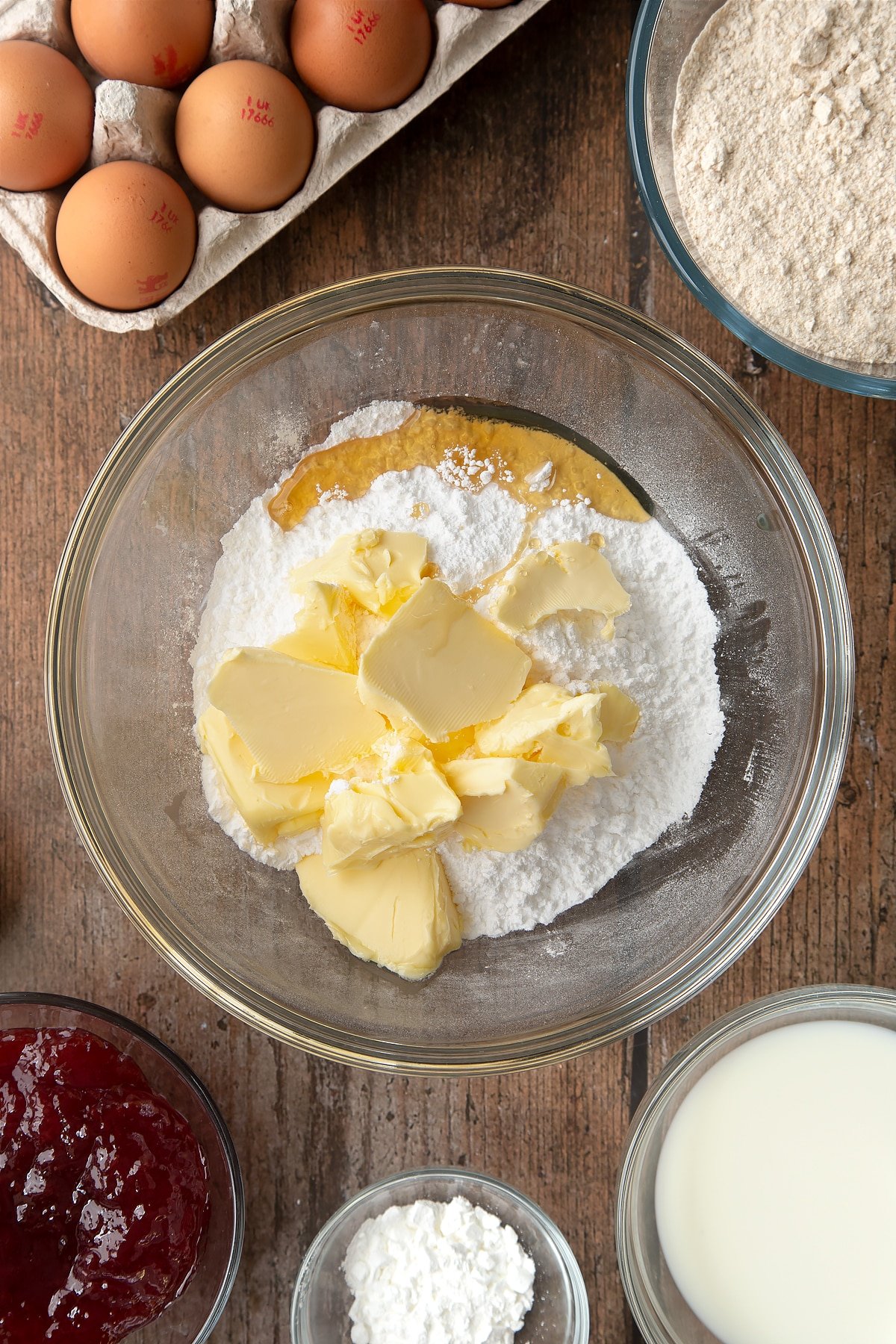 Overhead shot of sugar and butter in a large clear mixing bowl