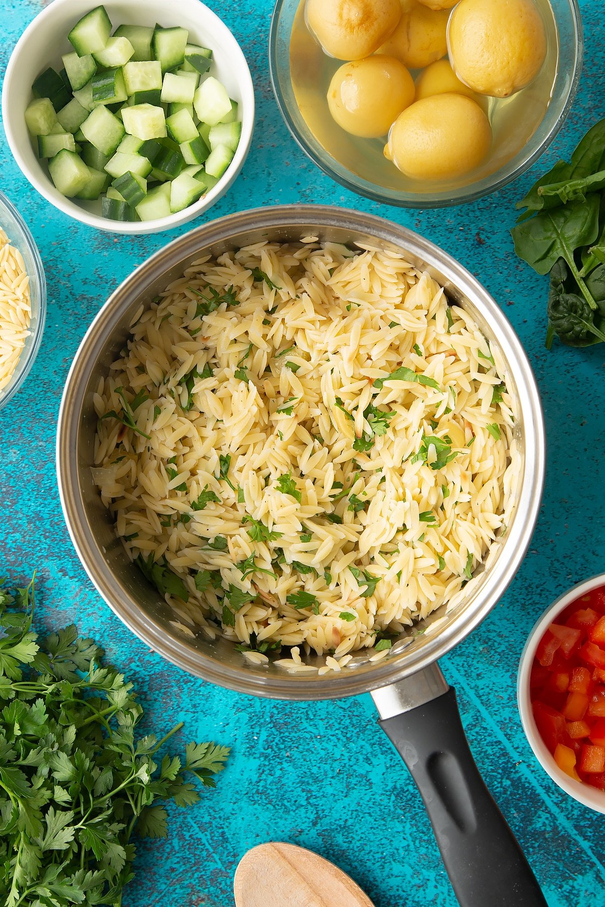 Cooked orzo in a saucepan mixed with preserved lemons, parsley, salt and pepper.