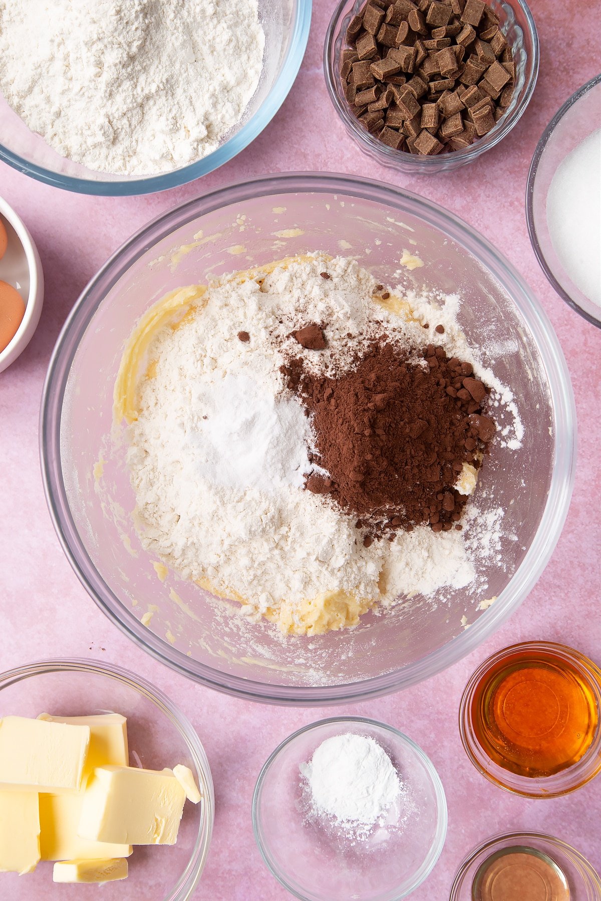 Overhead shot of flour, cocoa and baking powder in a large clear bowl