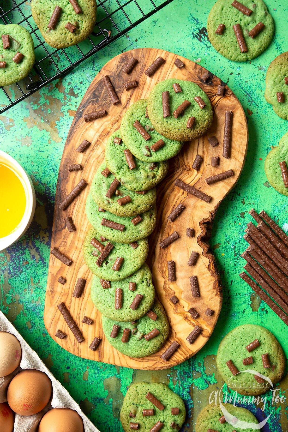 Matchmaker cookies arranged on a wooden board. More cookies surround the board.