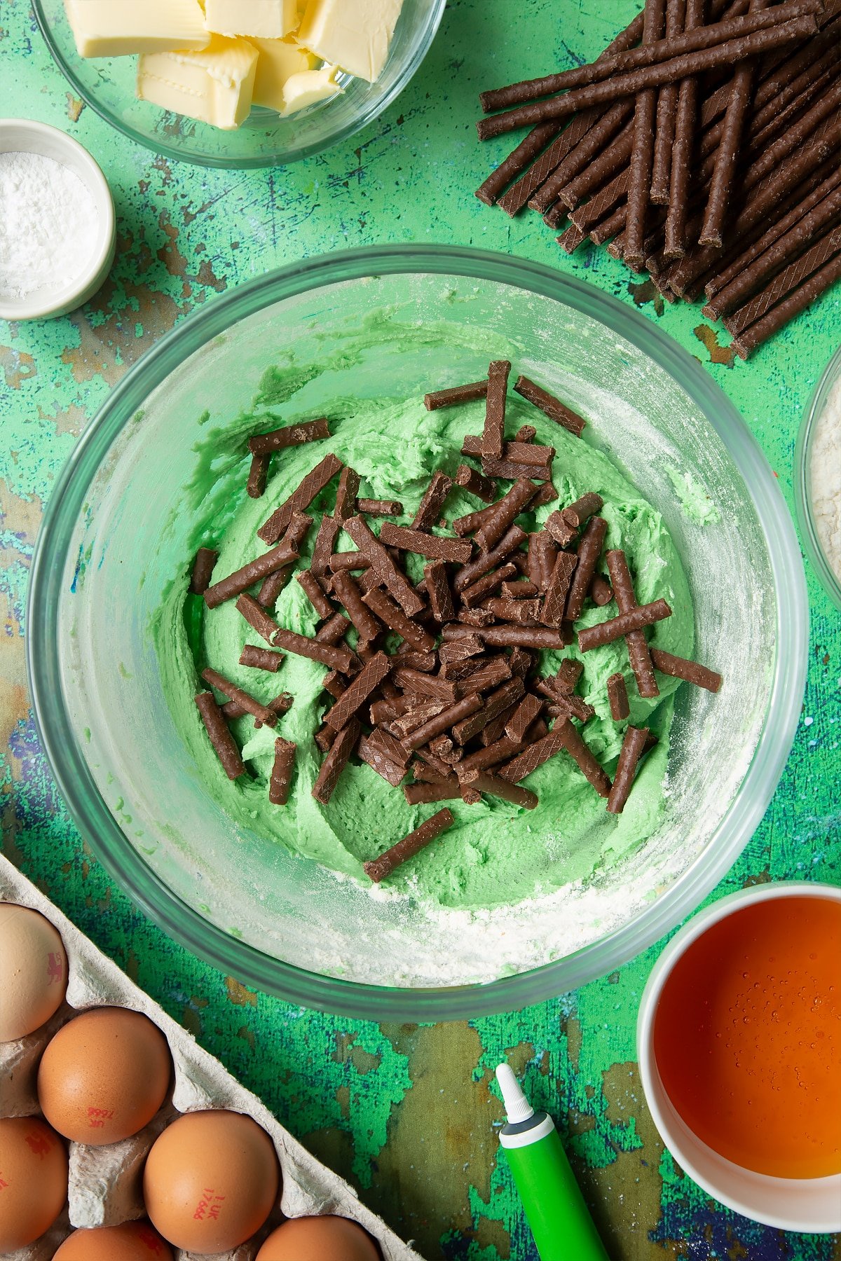 Green cookie dough in a mixing bowl, topped with Matchmaker pieces.