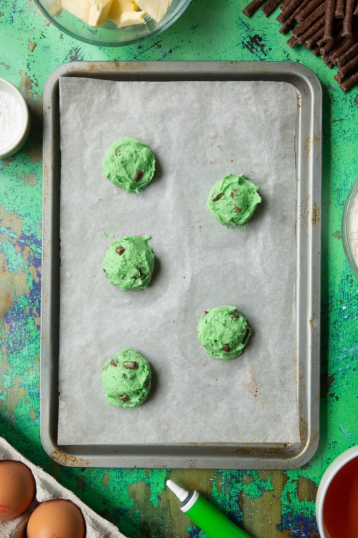 Matchmaker cookie dough scoops on a lined baking tray.