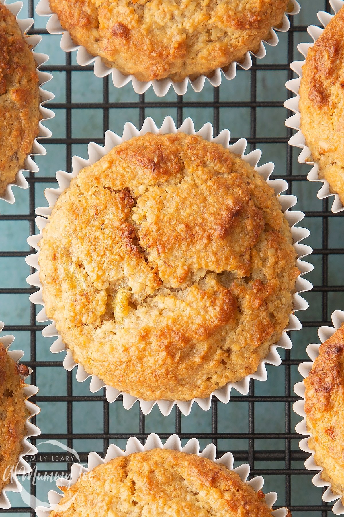 Overhead shot of Oat bran muffins on a baking rack with a mummy too logo in the lower-left corner