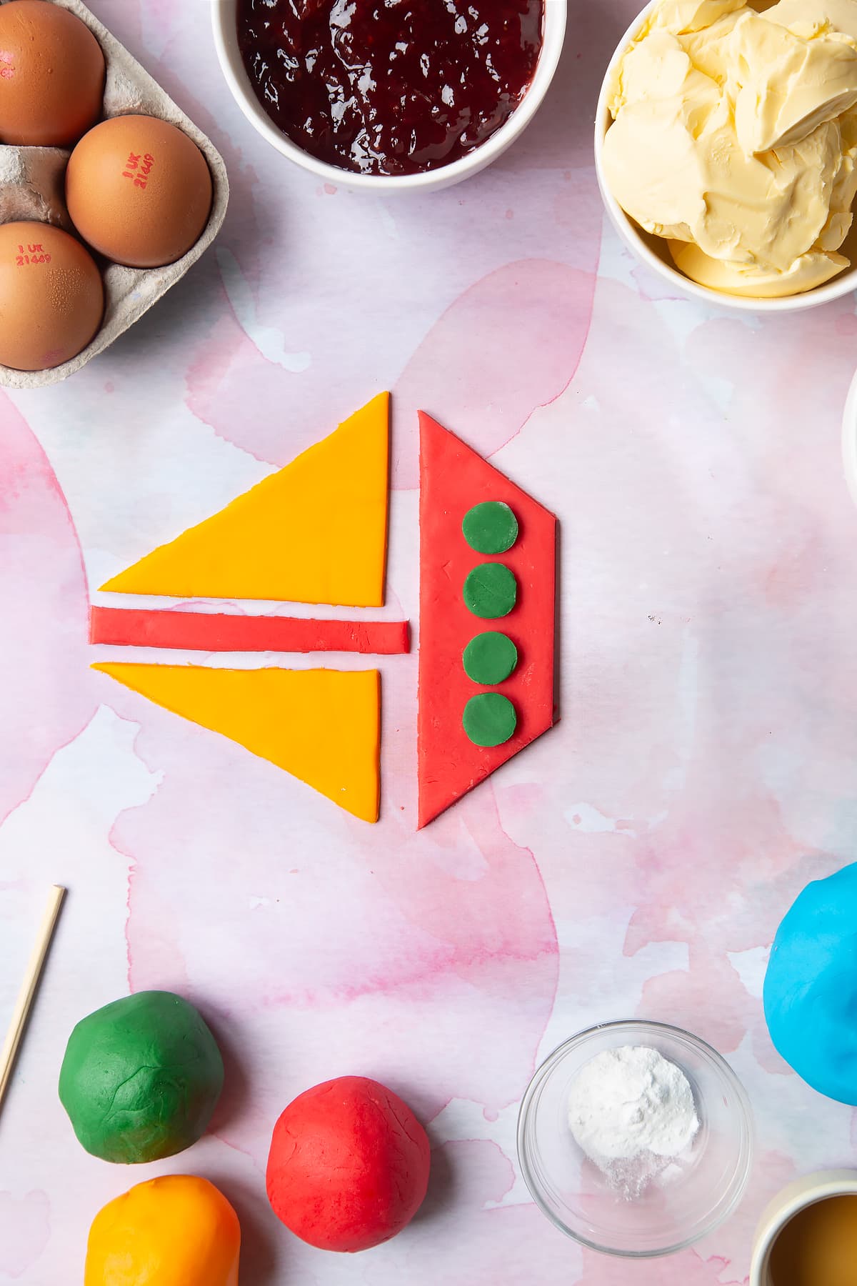 Overhead shot of shaped red, green and yellow sugar paste boat