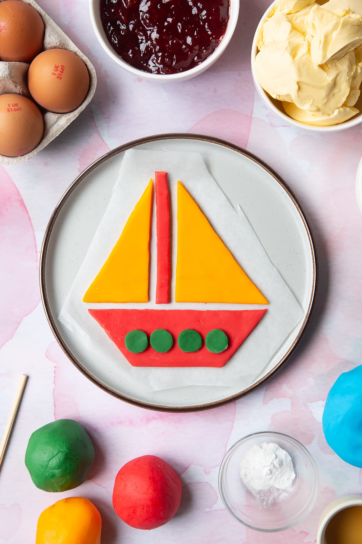Front angle shot of Sailing boat sugar paste with a mummy too logo in the lower-left corner