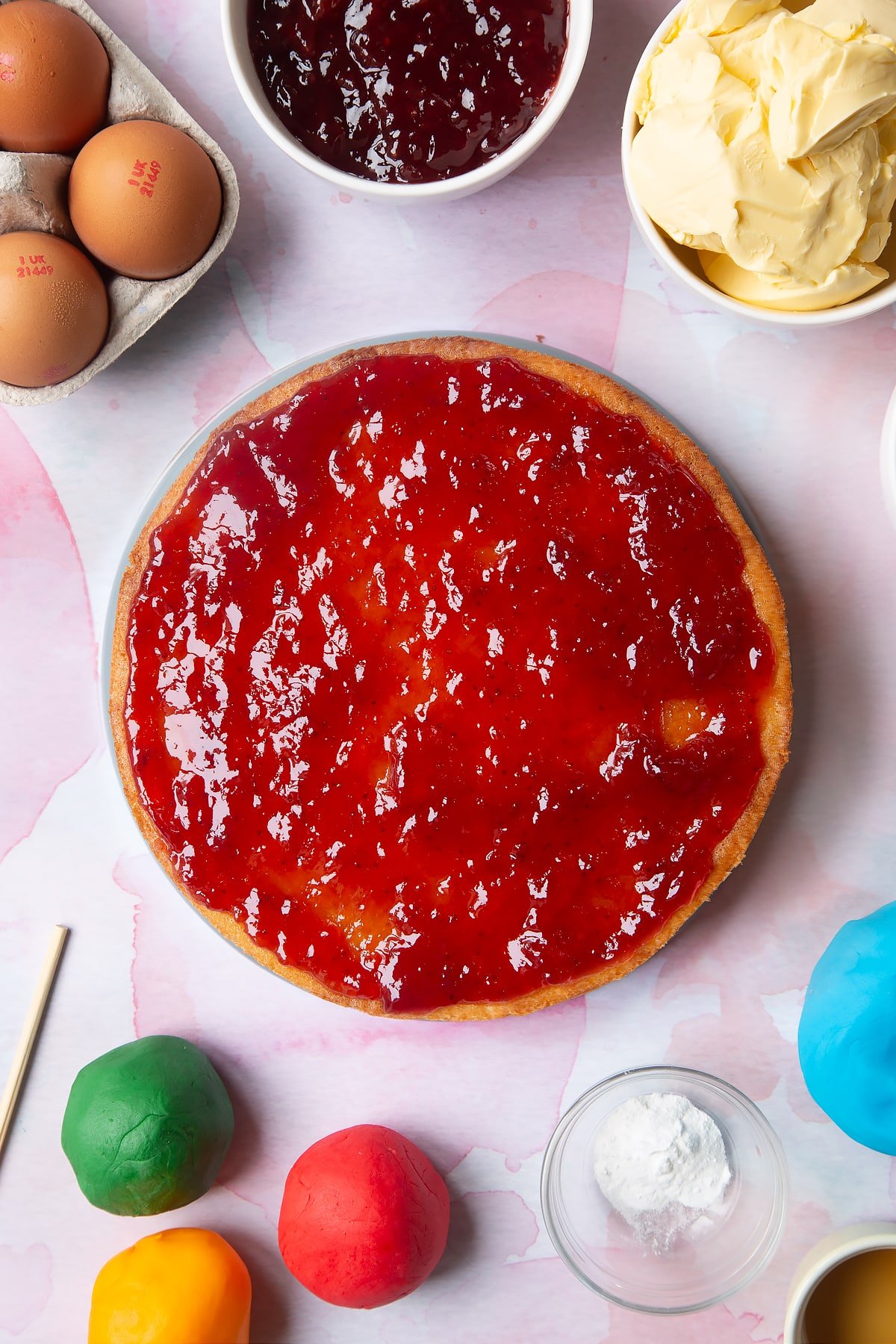 Overhead shot of smoothing the jam out on the cake. 