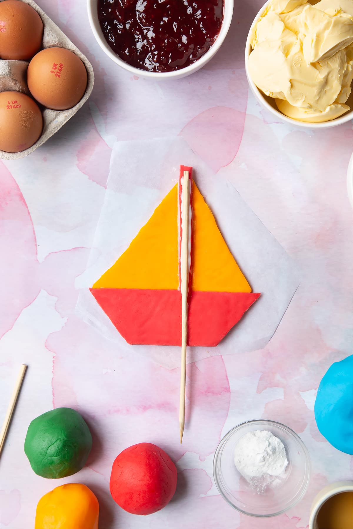 Overhead shot of attaching the skewer to the back of the boat made from sugar paste.