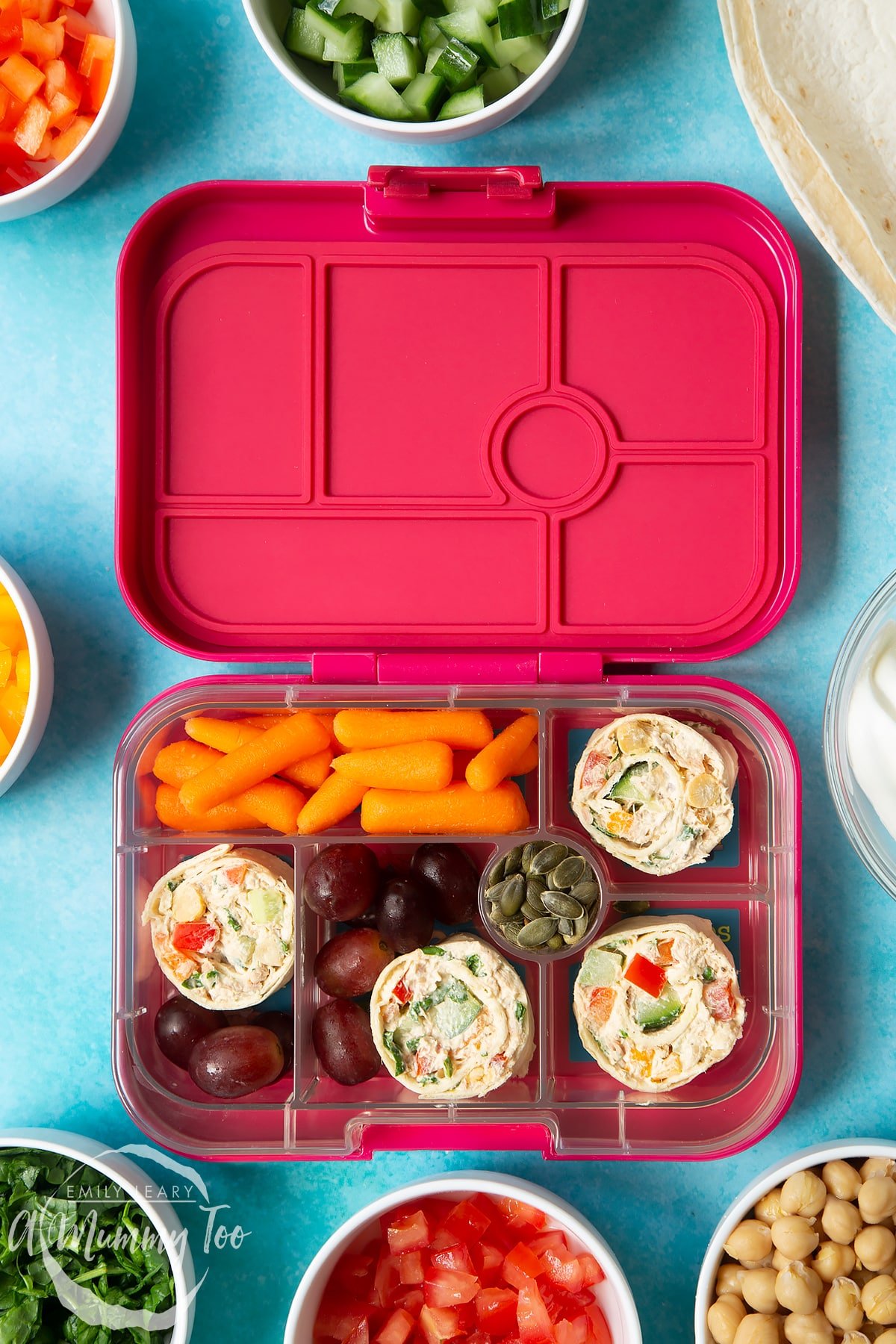 Tuna pinwheels in a lunchbox with fresh fruit and veg. 