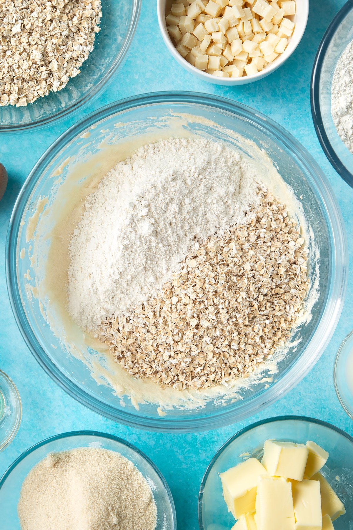 Overhead shot of mixed dough , flour and oats in a large bowl