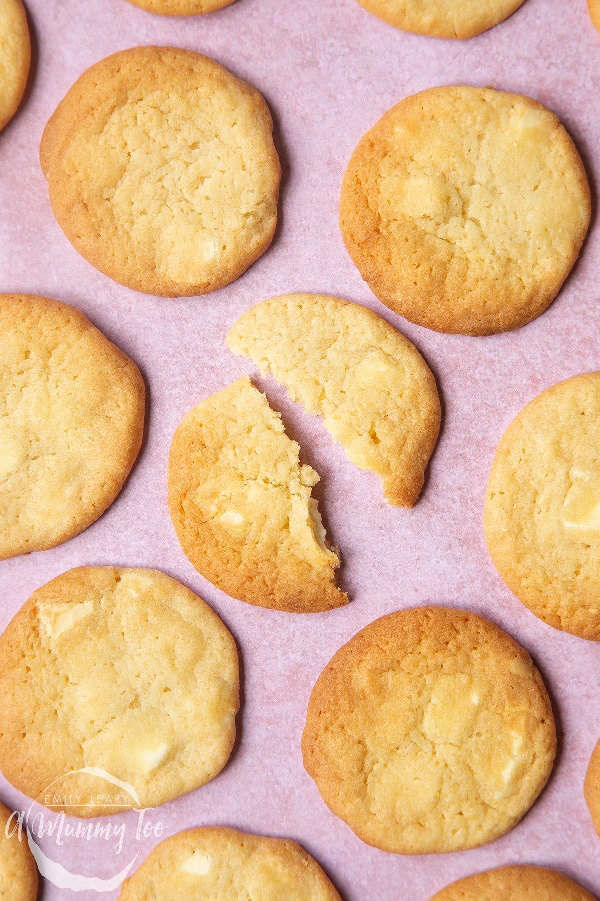 Overhead shot of halved soft white chocolate cookie with a mummy too logo in the lower-left corner