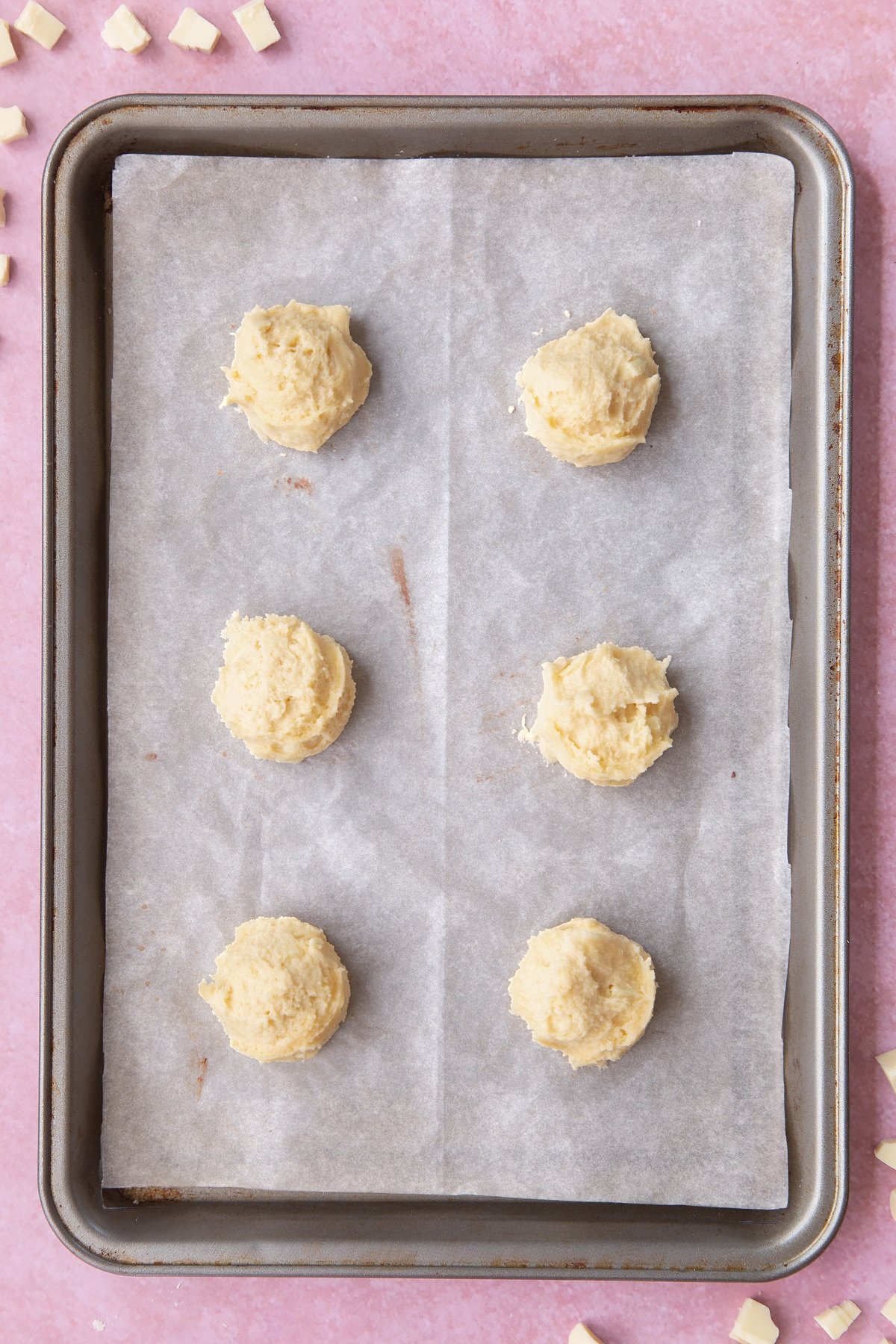 Overhead shot of cookie dough in balls on a baking sheet.