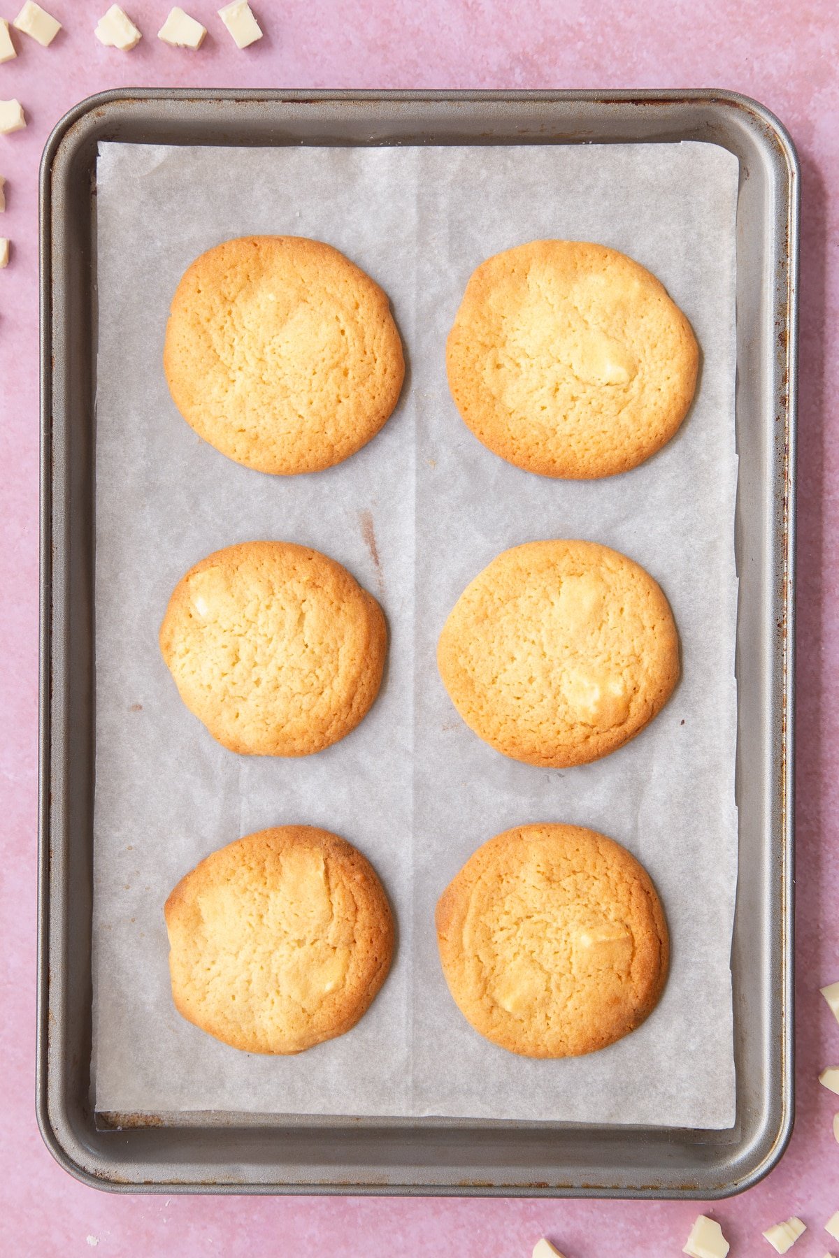 Overhead shot of the cooked white chocolate chip cookies on a baking sheet.