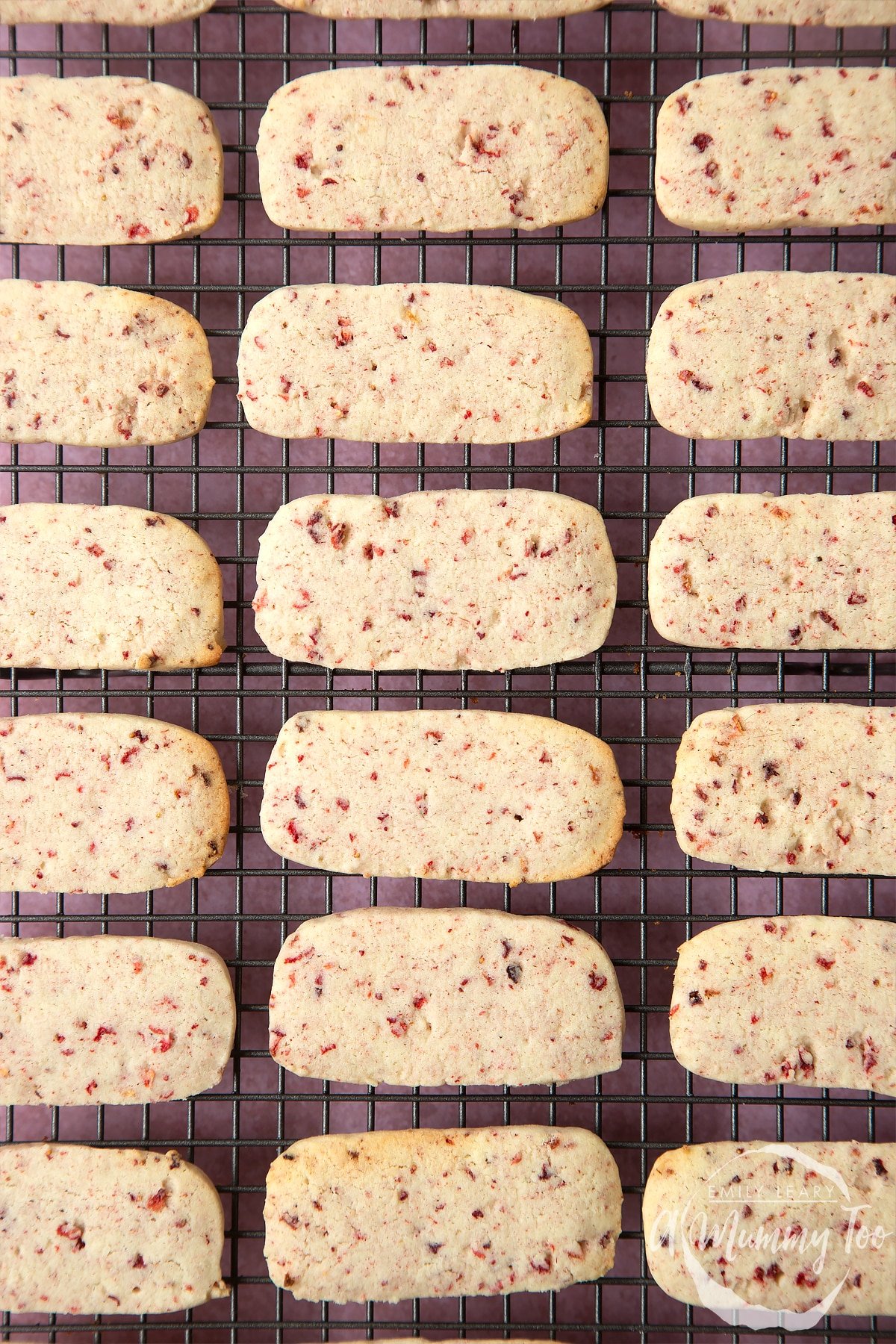 Strawberry biscuits lined up in rows on a cooling rack.