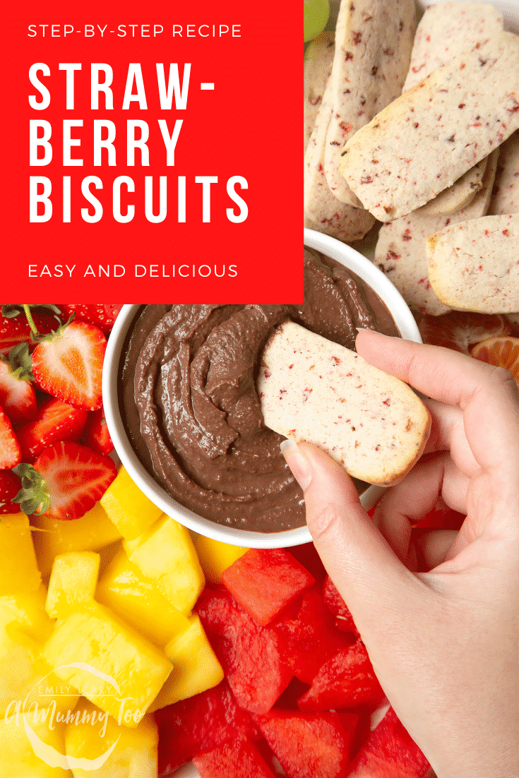 Strawberry biscuit being dipped in chocolate sauce. Surrounding the dip there's a number of different fruits. In the top right hand corner there's some text stating what the image is 'strawberry biscuits'.