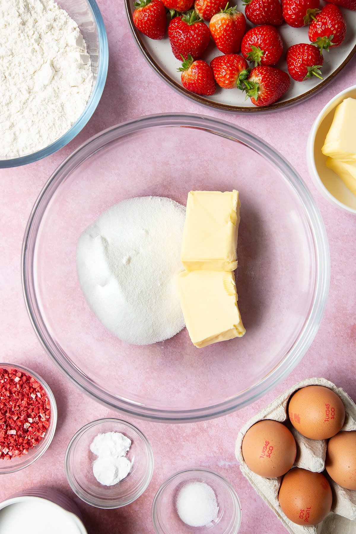 Butter and sugar in a bowl together. One of the two primary ingredients required to make strawberry biscuits.