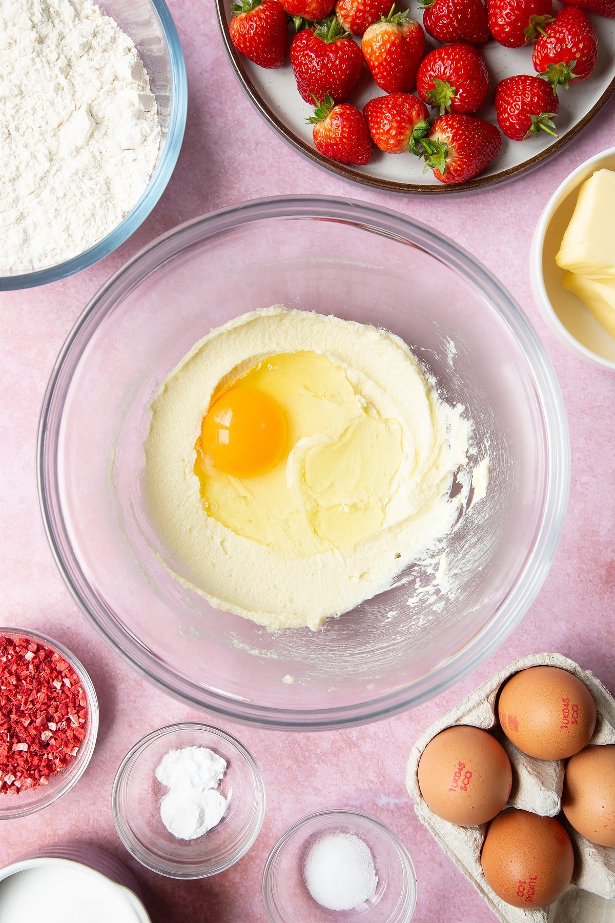 One egg added to the bowl of strawberry biscuits ingredients. 