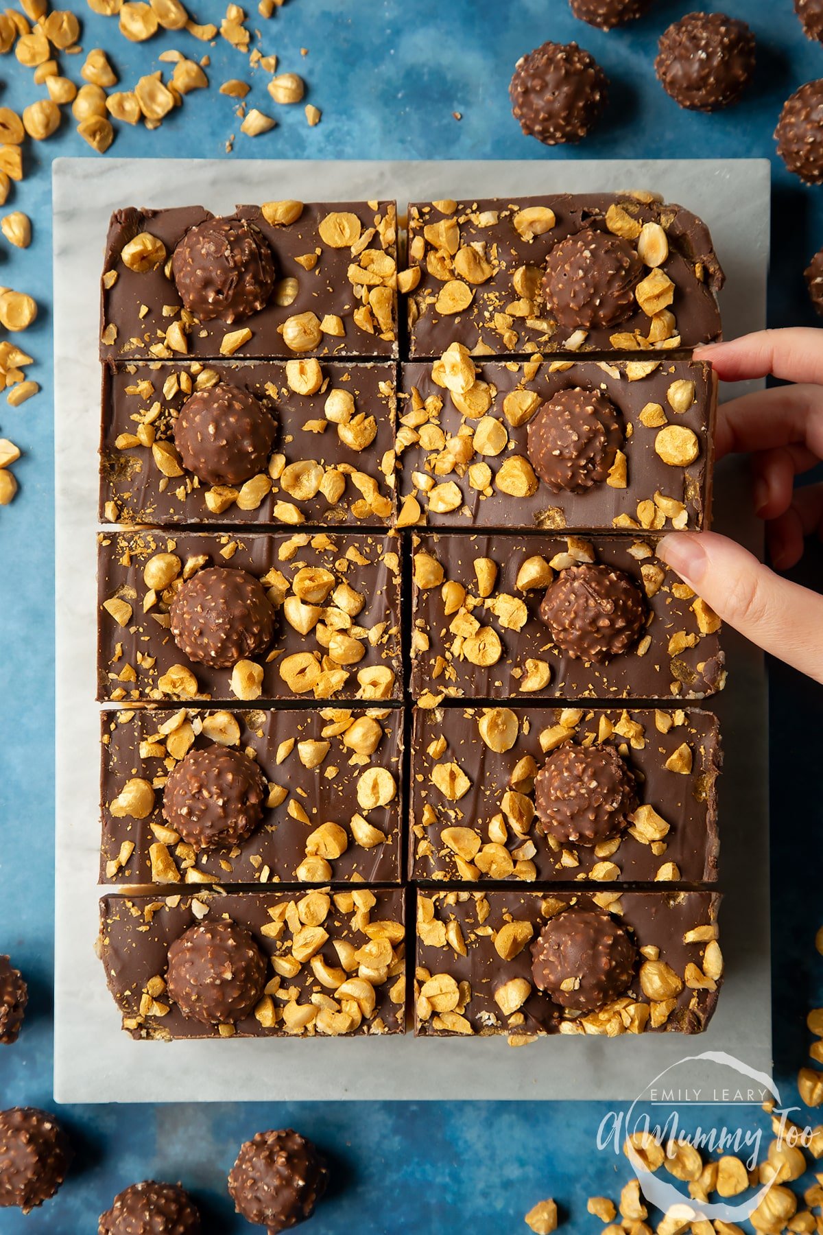 Marble board with Ferrero Rocher slices. A hand reaches for one.