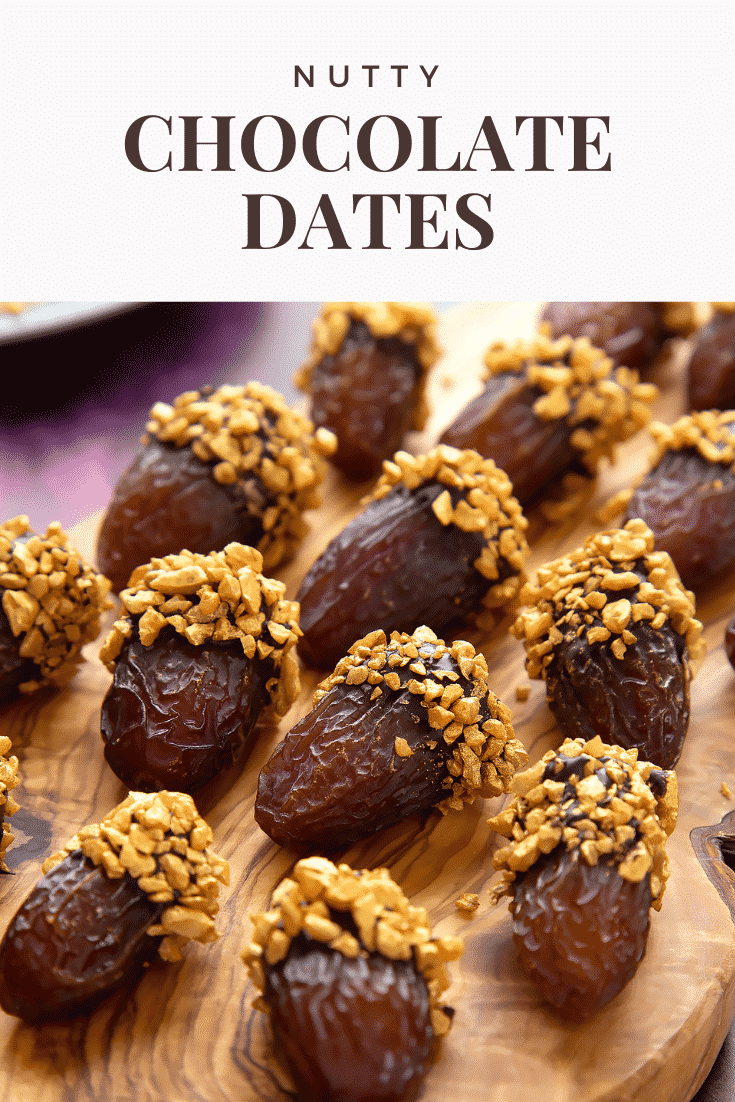 Medjool dates on a wooden board and. They have been dipped in chocolate and studded with gold chopped nuts. Caption reads: nutty chocolate dates