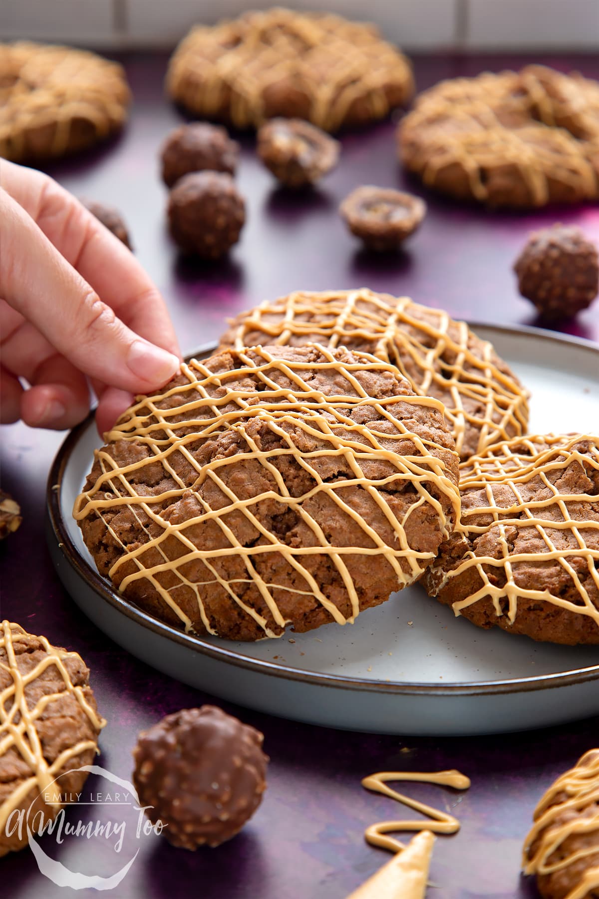 Ferrero Rocher cookies on a plate. A hand reaches to take one.