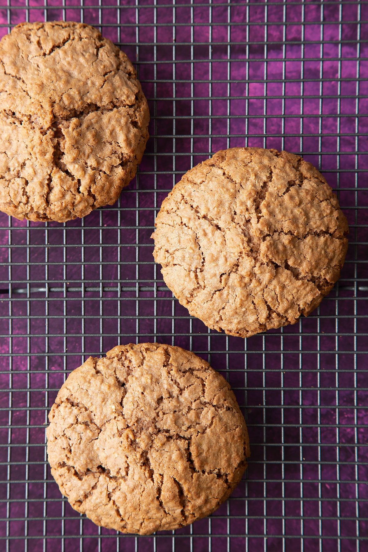 Three undecorated Ferrero Rocher cookies on a cooling rack.