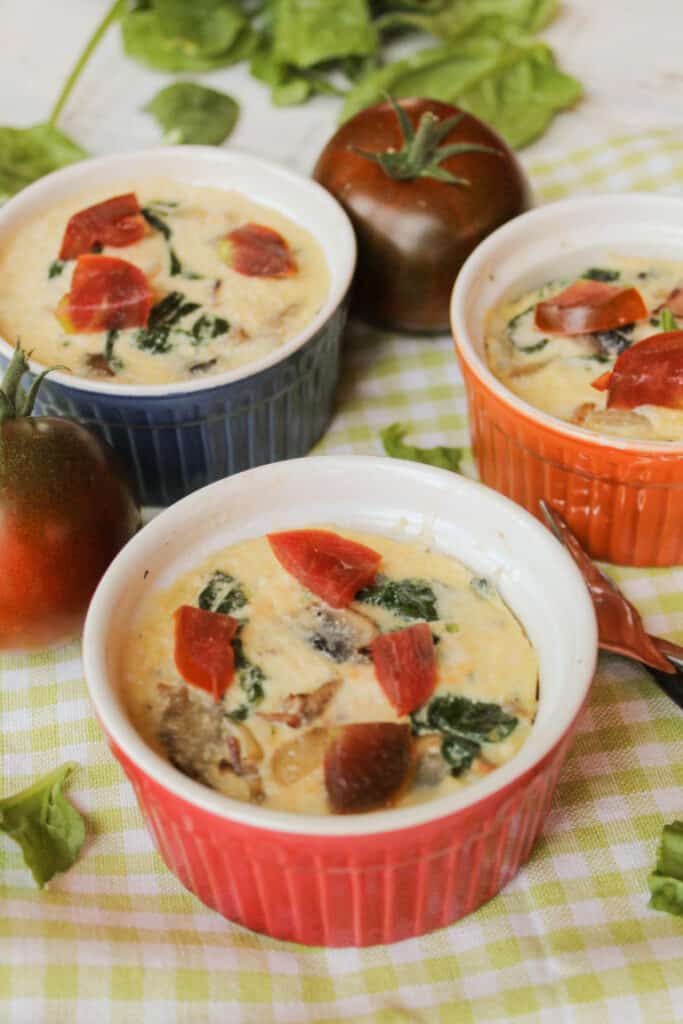 Three instant pot quiche cups in different coloured ceramic cups on a lime and white checked background. 