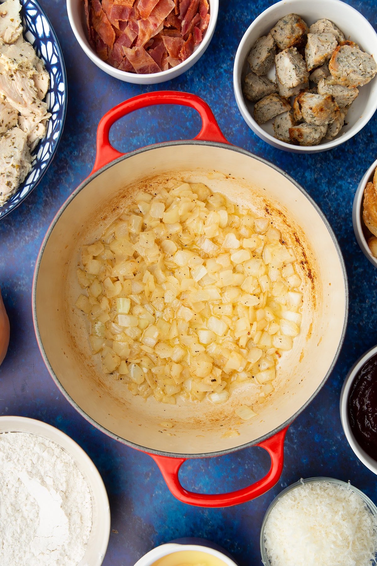 Fried onions in a pan. Ingredients to make a leftover Christmas dinner pie surround the pan.