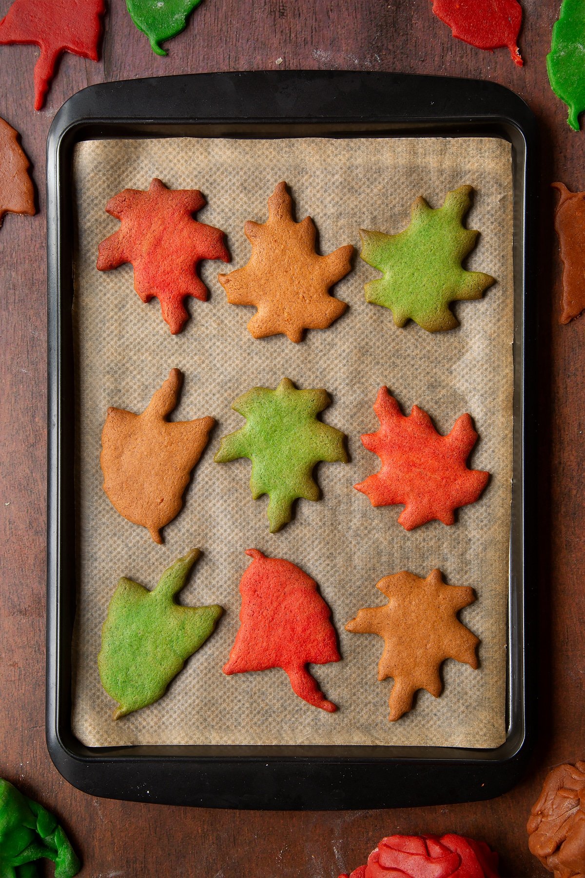 Autumn leaf cookies cooling on a tray lined with baking paper.