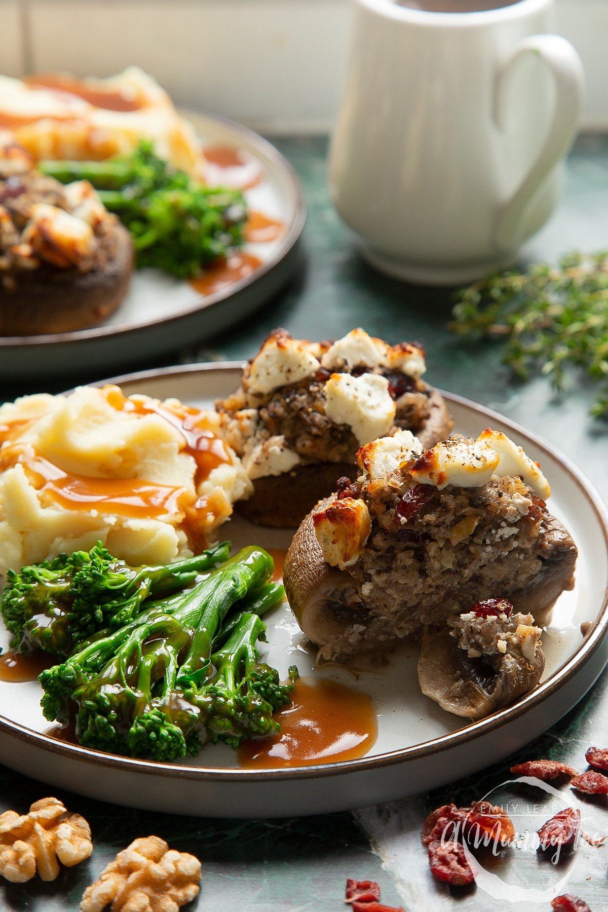 Front angle shot of crispy Christmas stuffed mushrooms drizzled with olive oil served on a gray plate