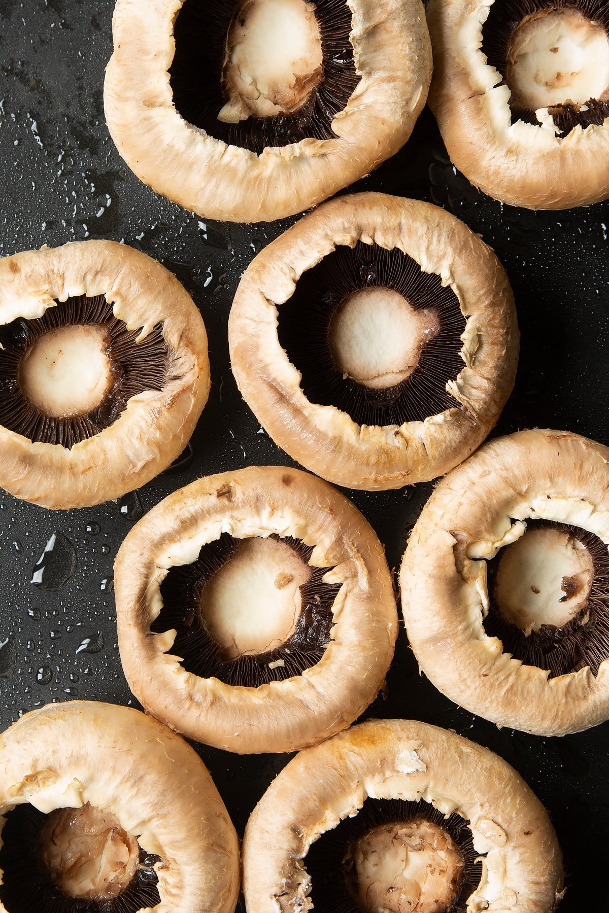 Overhead shot of mushrooms on a greased baking tray 