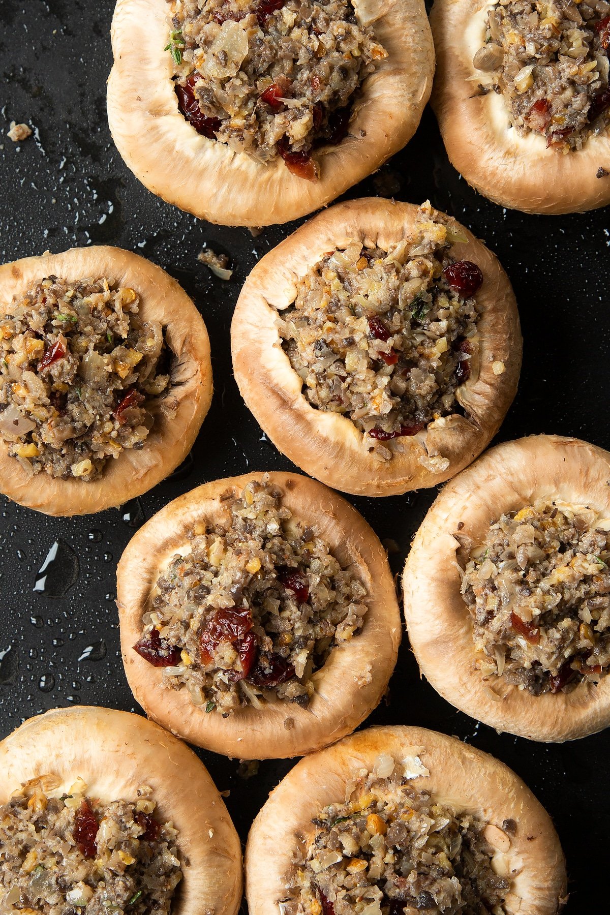 Overhead shot of filling inside mushrooms on a baking tray 