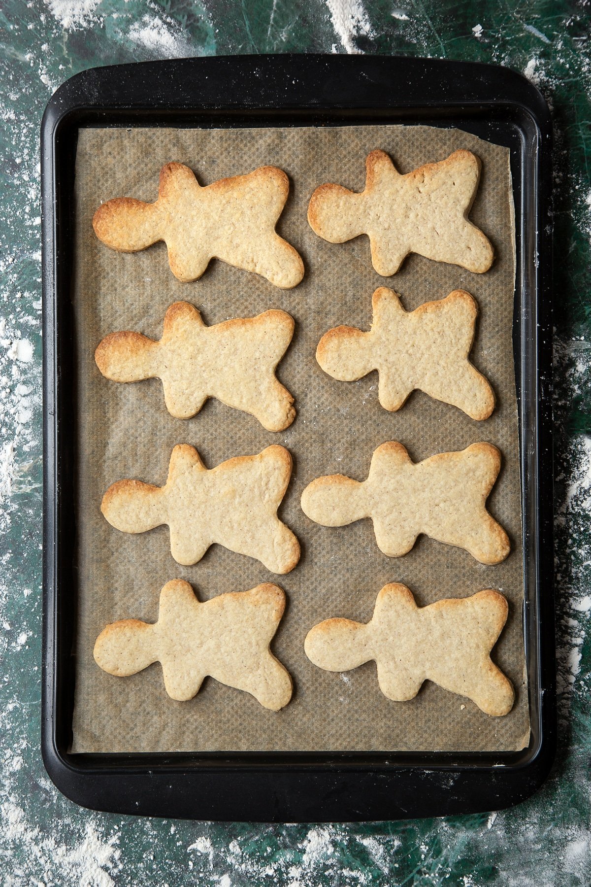 Baked cookies on a tray lined with baking paper.