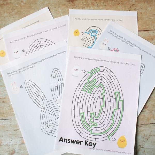 A collection of Easter-themed maze puzzles, printed on A4 paper, lying on a wooden backdrop. 