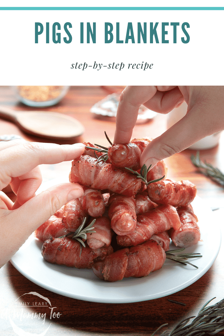 Forward facing shot of some pigs in blankets stacked on top of each other on a white plate with some text at the top of the image describing it for Pinterest.