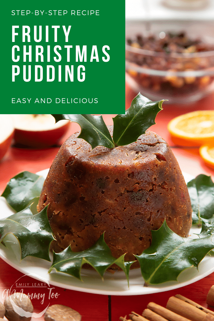 Front facing photo of a Christmas pudding on a white plate with some holly leaves at the side. There's some text at the top of the image describing it for Pinterest.