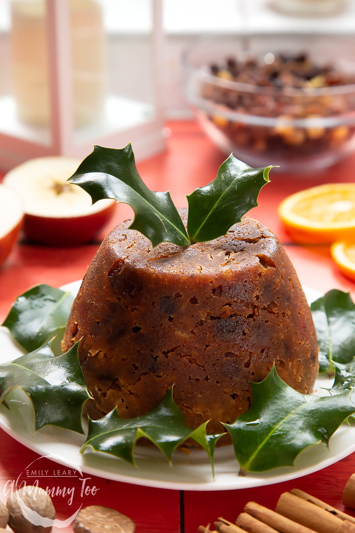 Front angle shot of Alcohol-free Christmas pudding served on a white plate with a mummy too logo in the lower-left corner