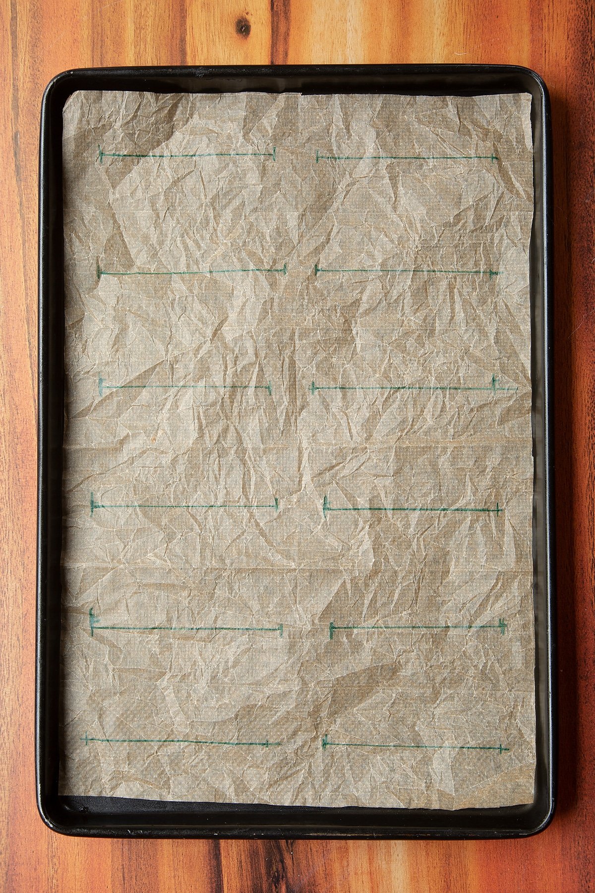 Overhead shot of a baking tray lined with marks on the paper. 