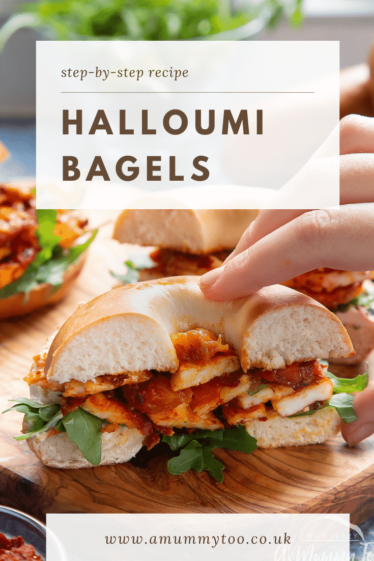 Two halloumi bagels on a wooden board. One is cut in half and a hand reaches for it. Caption reads: step-by-step recipe halloumi bagels