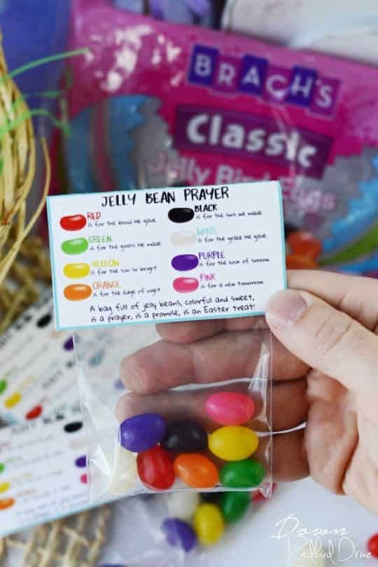 A hand holding a small bag of egg-shaped, coloured jelly beans with a custom Easter treat label.