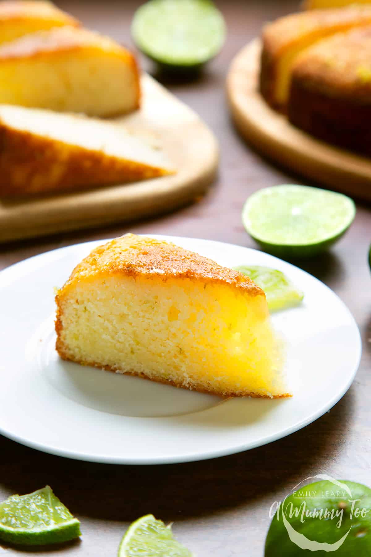 Slice of lime drizzle cake standing on a white plate.