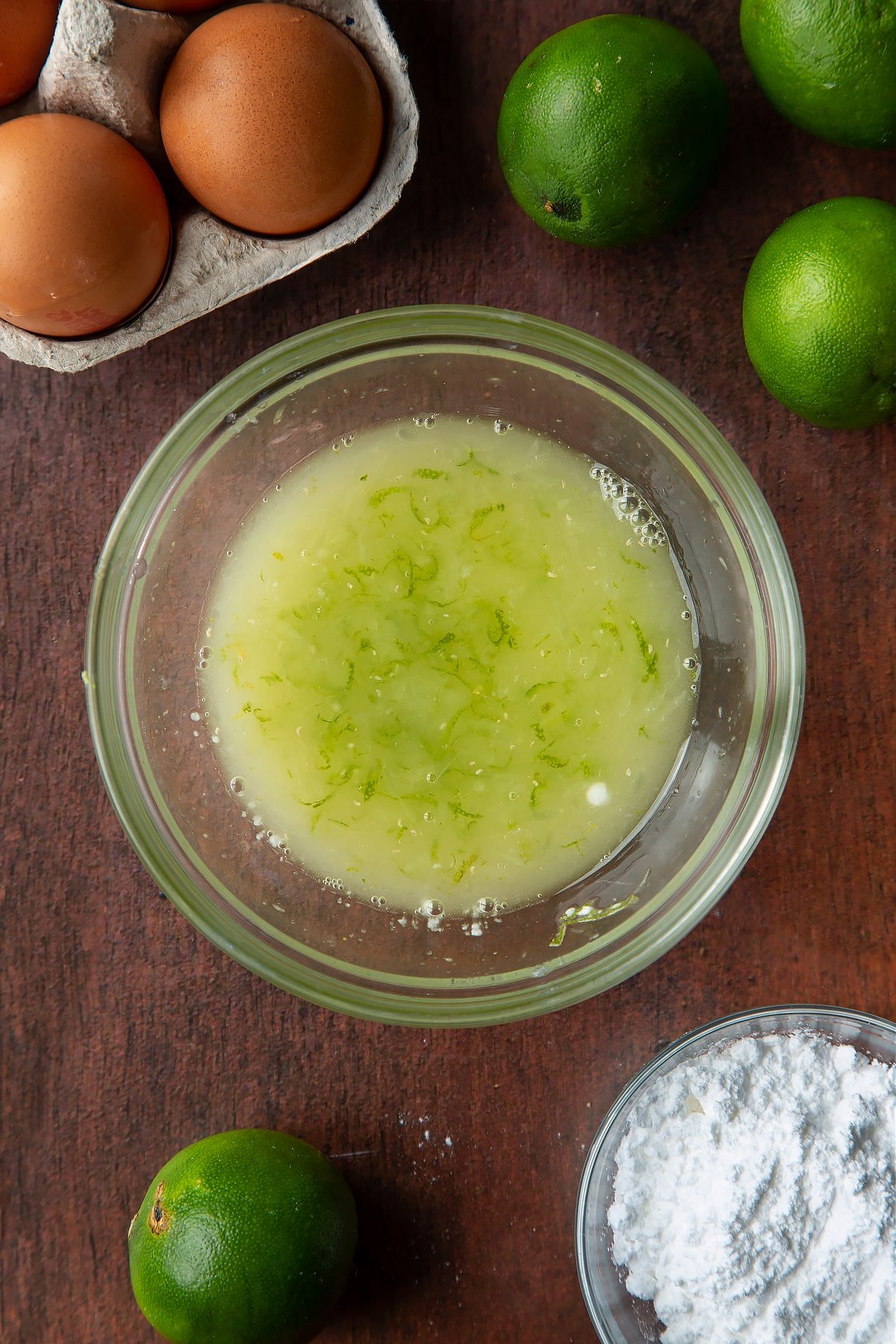 Lime juice and zest and icing sugar mixed together in a small bowl.