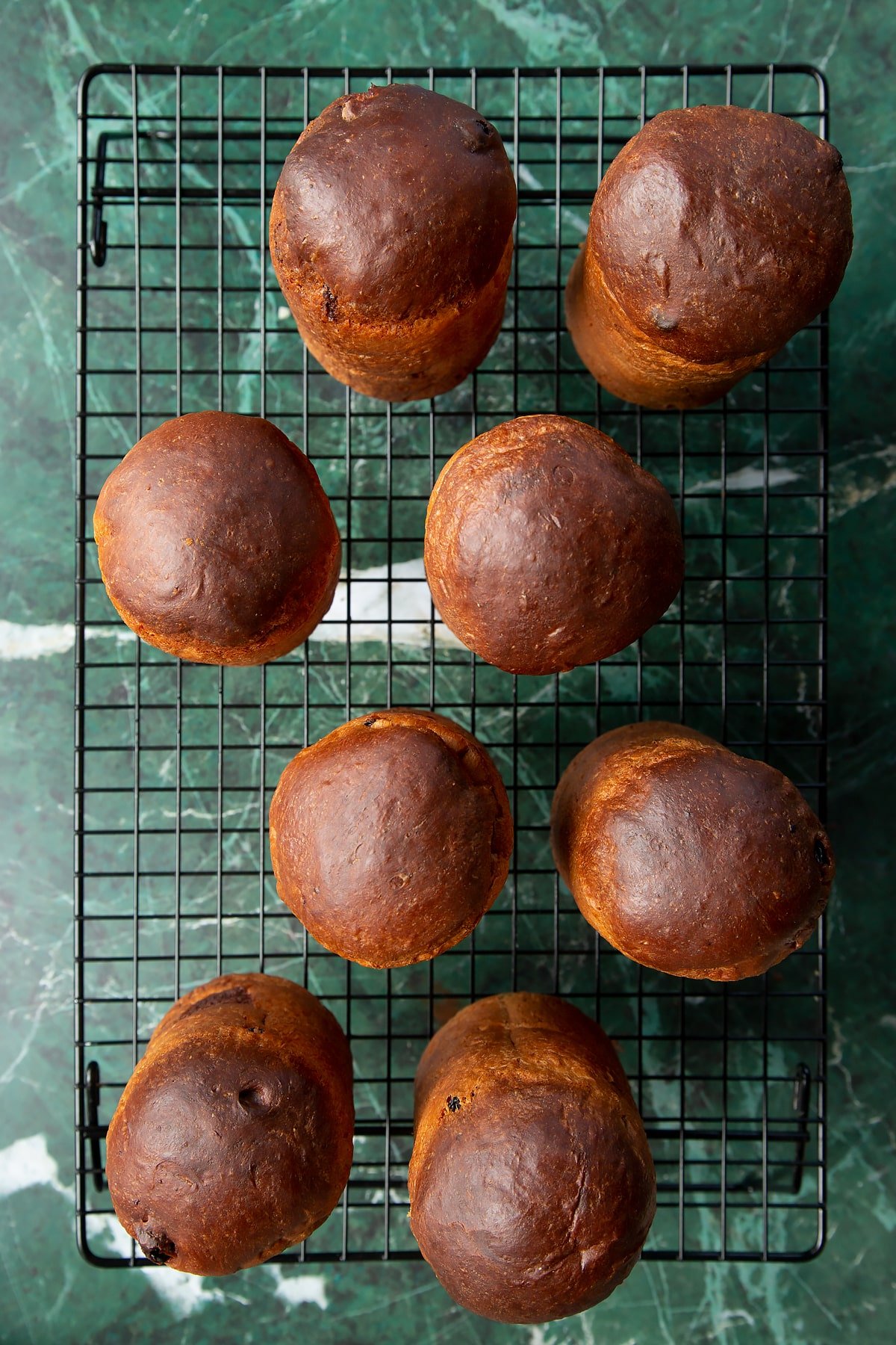 8 panettone cooling on a wire rack.